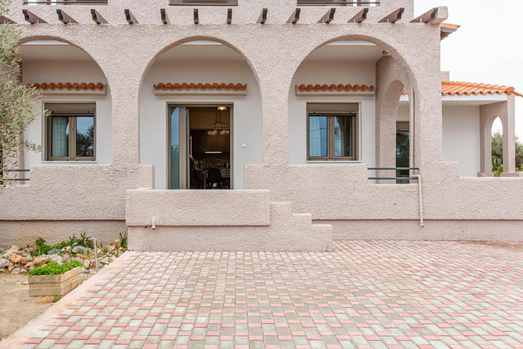 a house with two arched windows and a brick driveway at Stefania's Cosy Place in Stavros