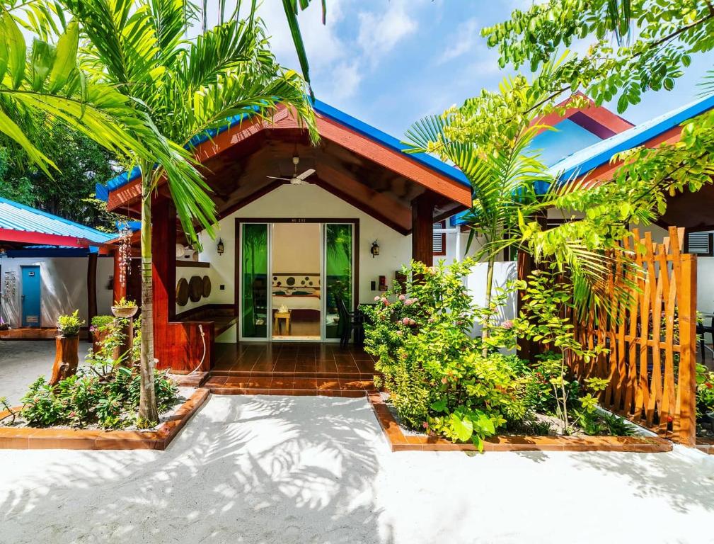 a villa with a tropical garden in front of a house at Beach Villa Ukulhas in Ukulhas