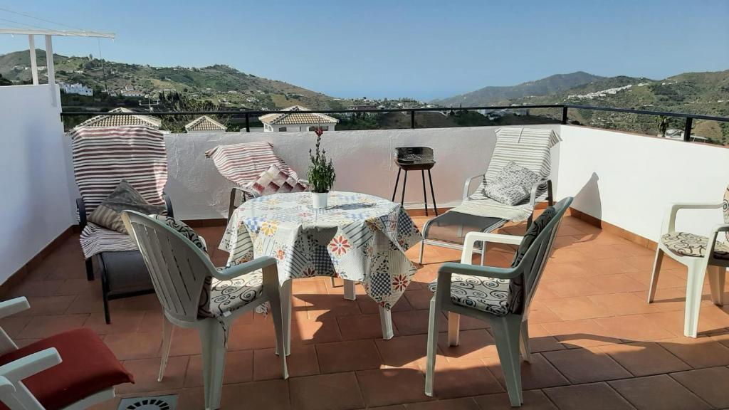 a patio with a table and chairs on a balcony at Vivienda rural Alborada in Cómpeta
