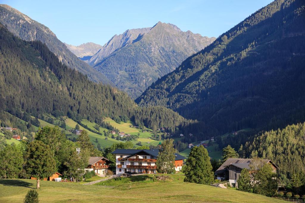 dom na wzgórzu z górami w tle w obiekcie Pension Stammerhof w Schladming