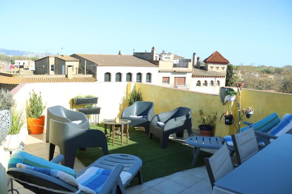 a patio with chairs and tables on a roof at Apartamentos Fornells in Castelló d'Empúries