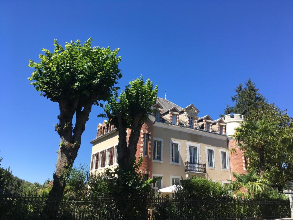 a large house with trees in front of it at Le Château Aspet B&B in Aspet