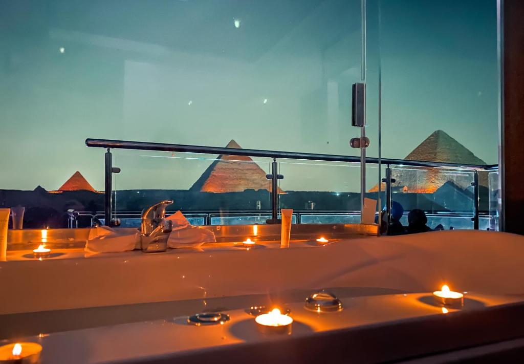 - une baignoire avec bougies dans une chambre avec vue dans l'établissement Best View Pyramids Hotel, au Caire