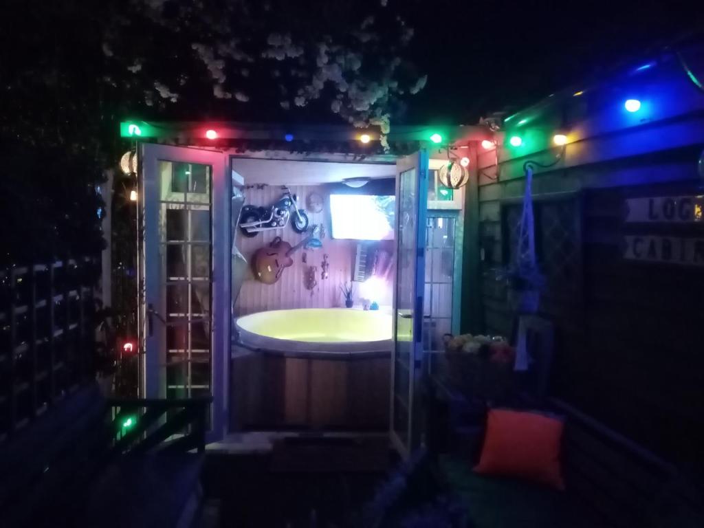 a bathroom with a tub with green lights at Chalet with hot tub room in Clanfield