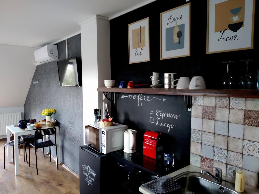 a kitchen with a black wall and a table at Rozmaring Vendégház in Orosháza