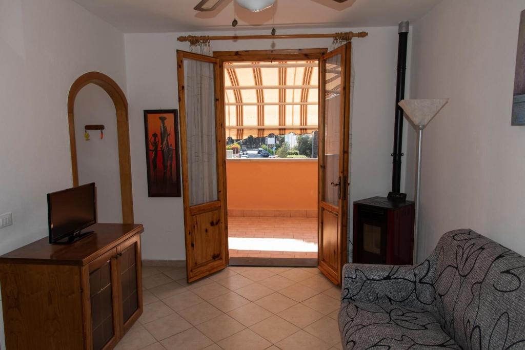 a living room with a couch and a television and a door at Appartamento il Bucaniere a Marina di Cecina in Marina di Cecina