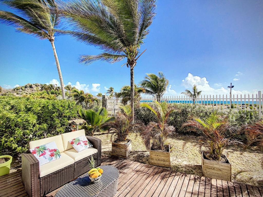 un osito de peluche sentado en un patio con palmeras en Princess Coco, Beachfront, Pool, Orient Bay, ultra fast Wifi, en Orient Bay