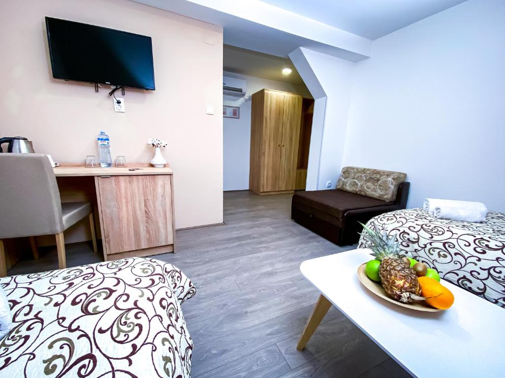 Pokój z łóżkiem i stołem z talerzem jedzenia w obiekcie Kiko apartmani w mieście Zrenjanin