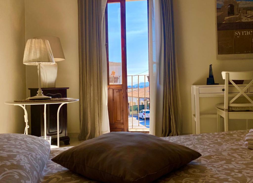 a bedroom with a bed with a view of a balcony at Il filo di Arianna, ad un passo da tutto in Syracuse