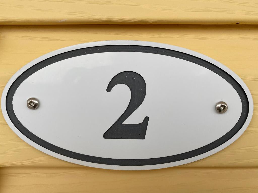 a white and black sign on a wooden wall at The Pines Motel and Cottages in Rustico