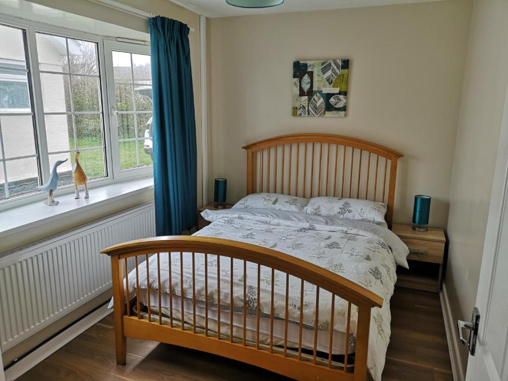 a bedroom with a wooden bed and a window at No. 9 in Swansea