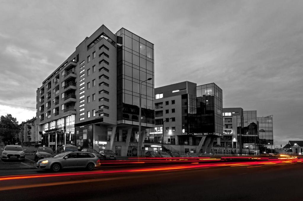 a building with cars parked in front of it at Premier Hotel Miskolc in Miskolc