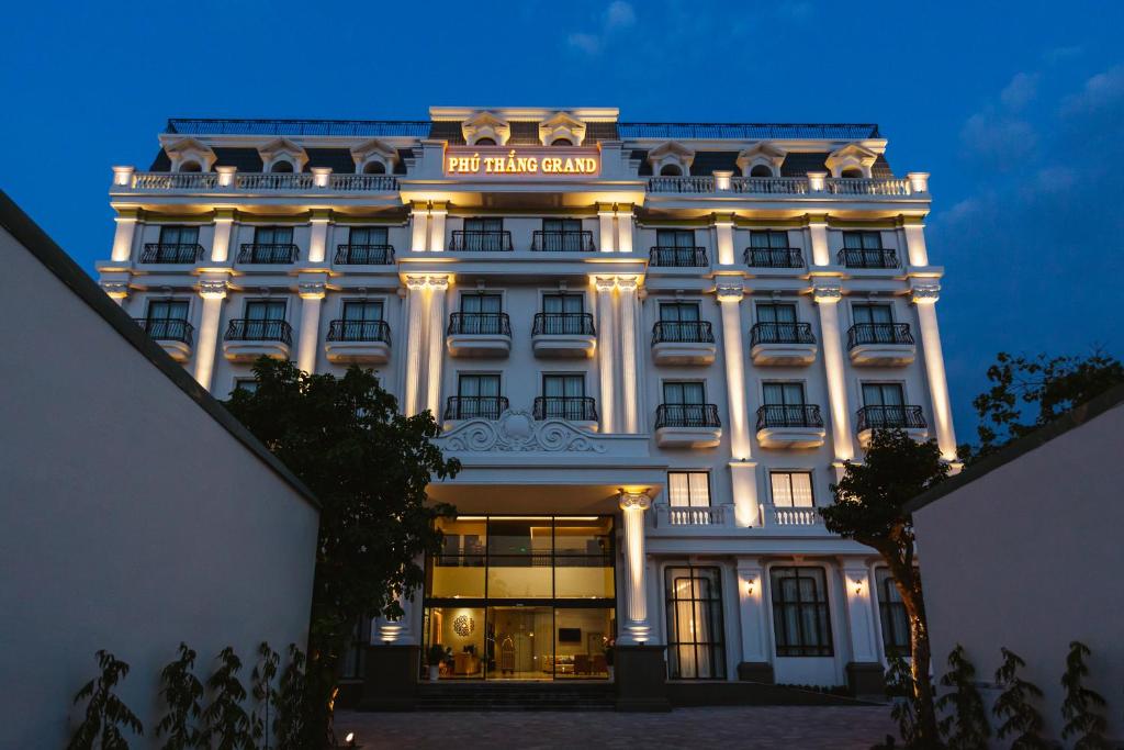 un gran edificio blanco con un cartel. en PHU THANG GRAND HOTEL, en Ðức Hòa