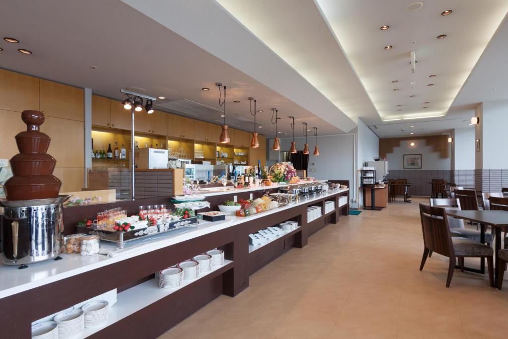 a restaurant with a buffet line with tables and chairs at Ueda Tokyu REI Hotel in Ueda