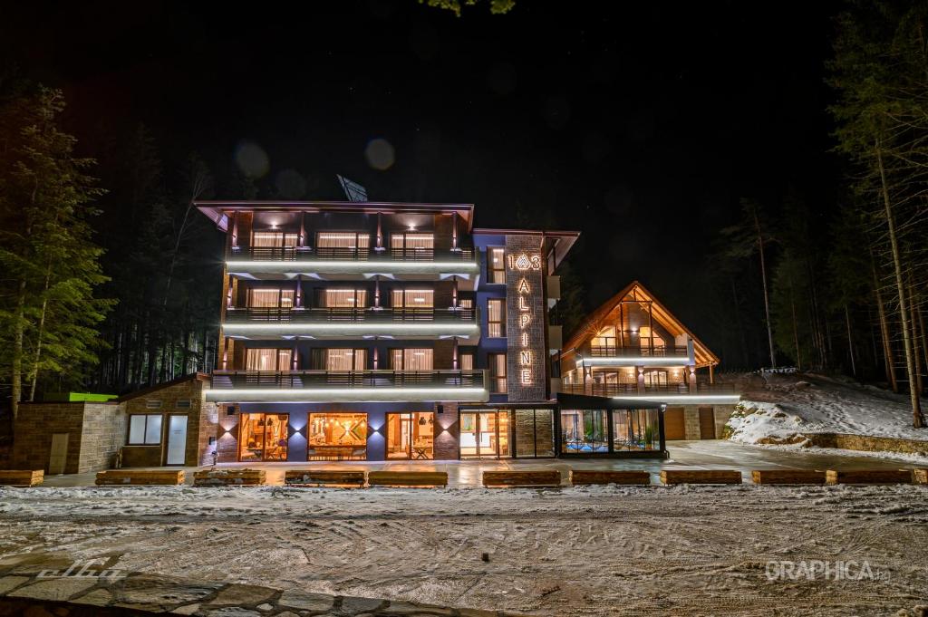 une maison dans les bois la nuit dans l'établissement 103 Alpine Hotel, à Panichishte