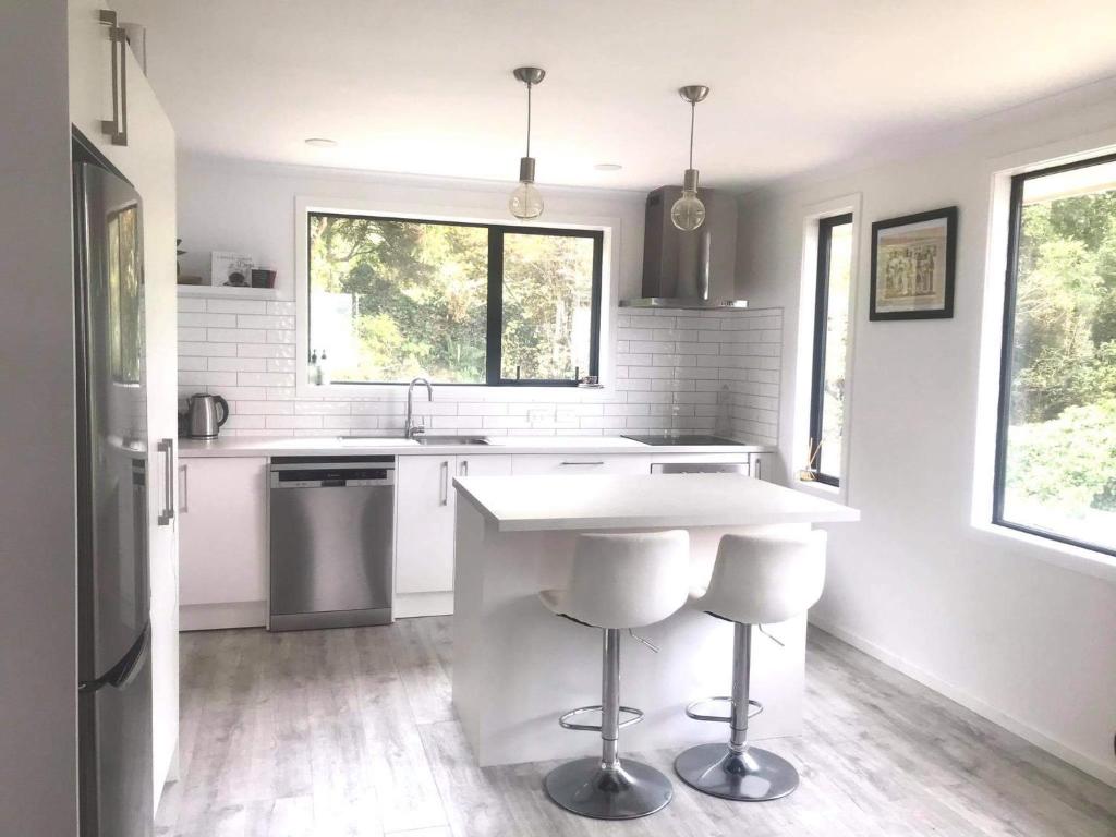 a white kitchen with a counter and a sink at Harbour Side Views in Dunedin