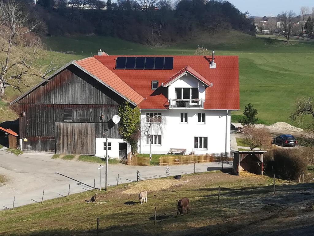 une grande maison blanche avec un toit rouge dans l'établissement Märzenburghof, à Kaufbeuren