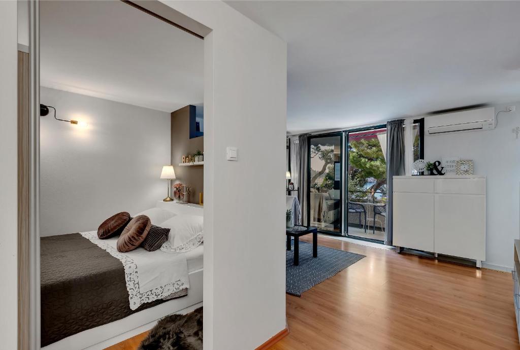 a bedroom with a bed and a large window at Apartment Mucrum in Makarska
