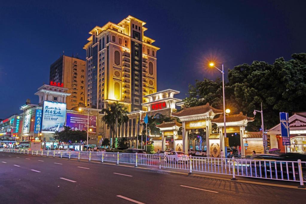 uma rua da cidade à noite com edifícios altos em Panyu Hotel em Guangzhou