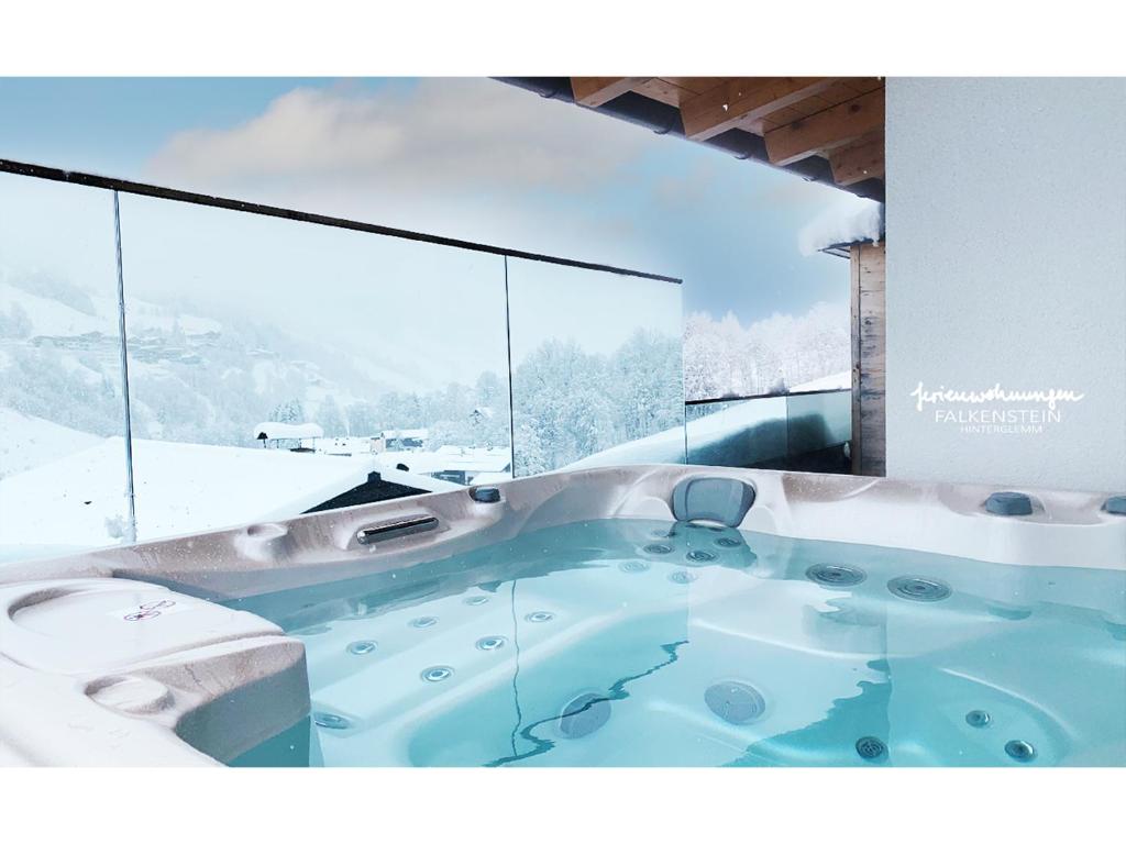 a jacuzzi tub in front of a large window at Ferienwohnungen Falkenstein Hinterglemm in Saalbach Hinterglemm