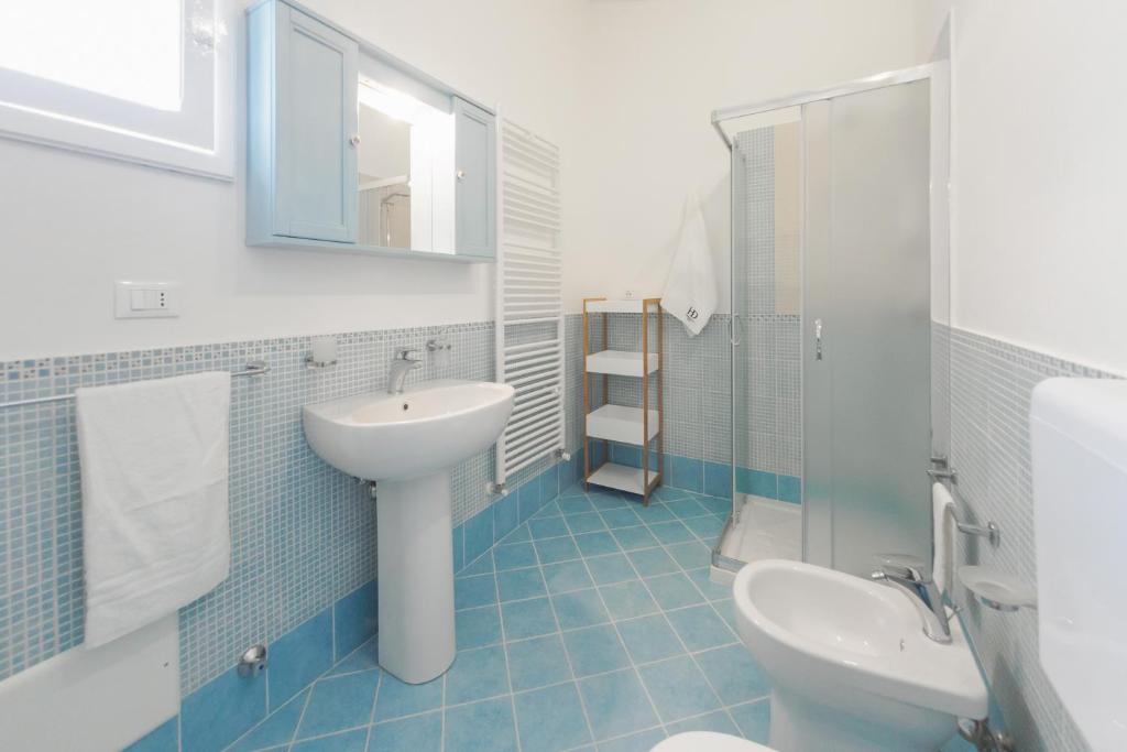 łazienka z umywalką, toaletą i lustrem w obiekcie Casa Vacanze Penelope w mieście Alessano