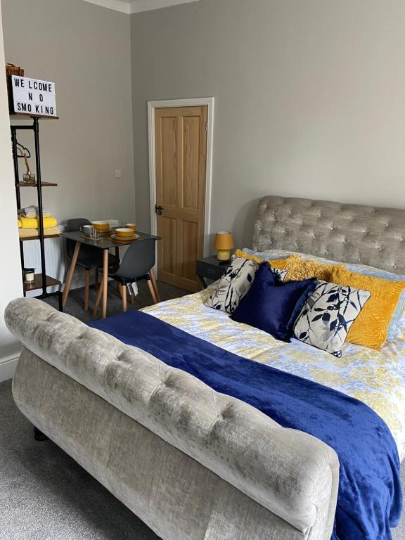 a bedroom with a large bed with a blue blanket at Cambridge Villas Private Studio Lytham St Annes in Saint Annes on the Sea