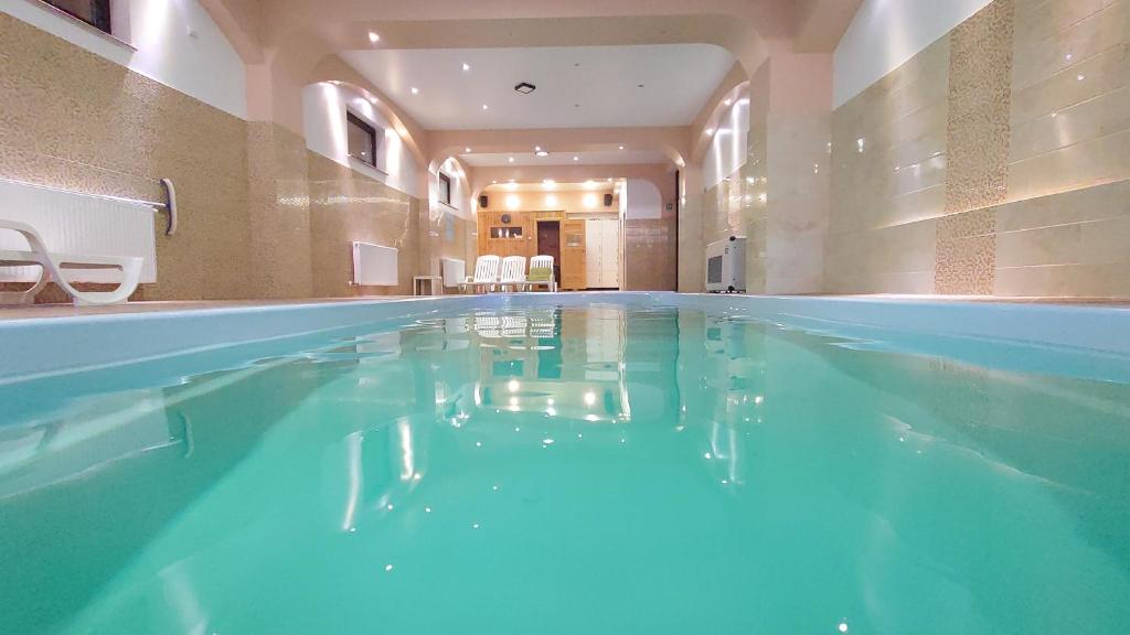 a swimming pool with blue water in a building at Pensiunea Mușatinii in Putna