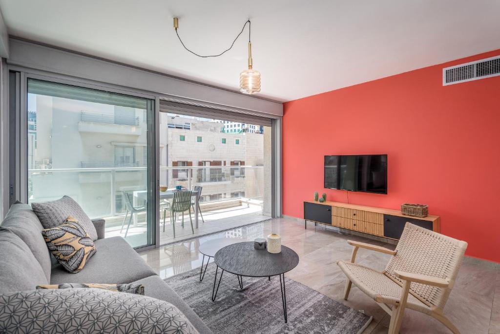 ein Wohnzimmer mit einem Sofa und einem TV in der Unterkunft 3 Bedrooms apt balcony & parking near banana beach in Tel Aviv