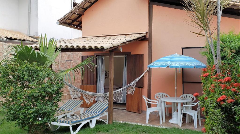 een patio met een hangmat en een tafel en stoelen bij Karina Estudio in Praia do Forte