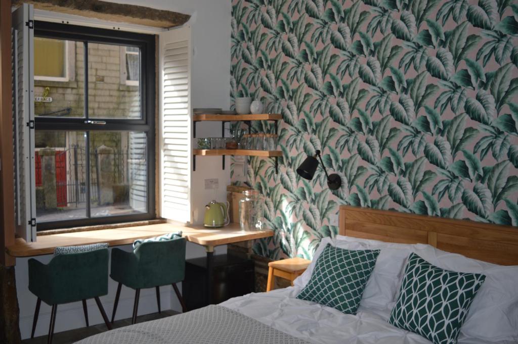 Schlafzimmer mit einem Bett, einem Fenster und einem Schreibtisch in der Unterkunft Grooms House in Hebden Bridge