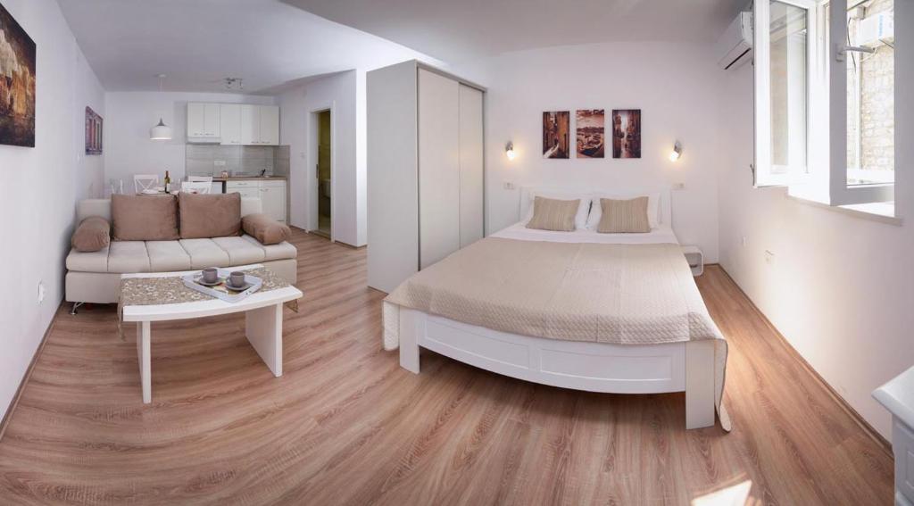 a bedroom with a large bed and a couch at Luce in Budva