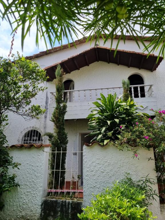ein weißes Haus mit einem Zaun davor in der Unterkunft Tatami Hostel in Bucaramanga