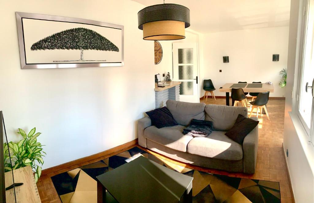 een woonkamer met een bank en een tafel bij Literie Haut de gamme entre gare et centre ville in Duinkerke