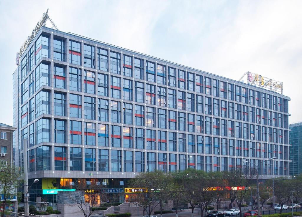 un gran edificio de cristal con muchas ventanas en Beijing Xinxiang Yayuan Apartment (Wangfujing), en Beijing