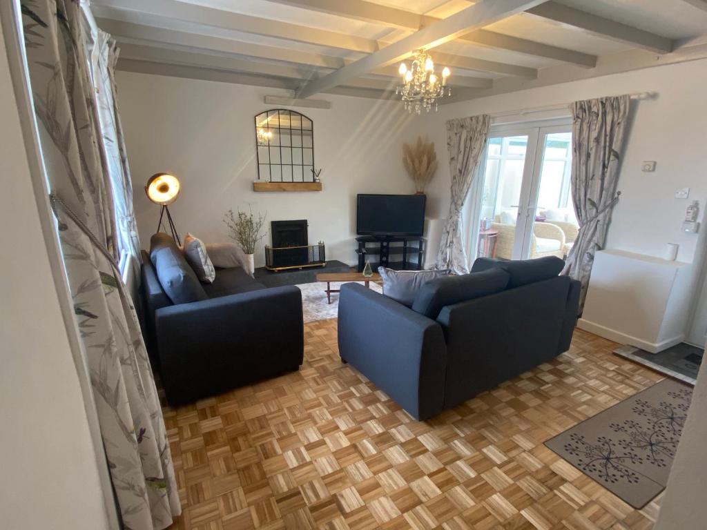 a living room with two couches and a television at The Cottage in Pembrokeshire