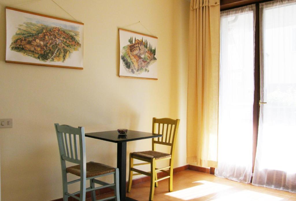 uma sala de jantar com uma mesa e duas cadeiras em I Borghi em Empoli