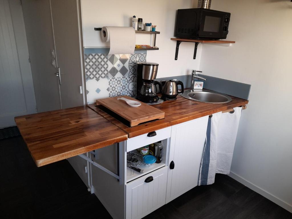 cocina con encimera de madera y fregadero en APPARTEMENT VUE PORT CROUESTY, en Arzon