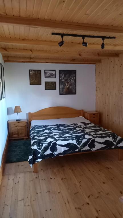um quarto com um edredão preto e branco numa cama em Dom nad jeziorem em Gostynin
