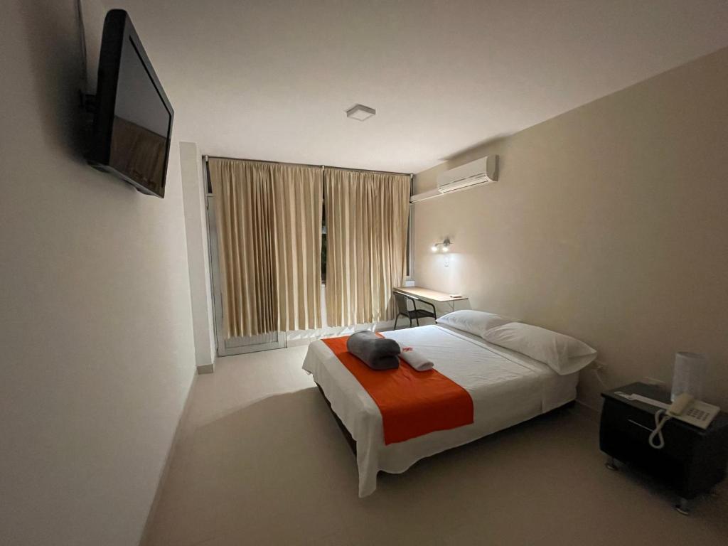 a bedroom with a bed and a television in it at Hotel Luna Roja del Llano in Yopal