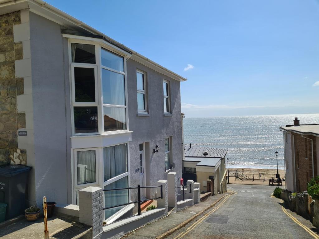 a white house with a view of the ocean at Beautiful Seaside Apartment With Parking in Ventnor