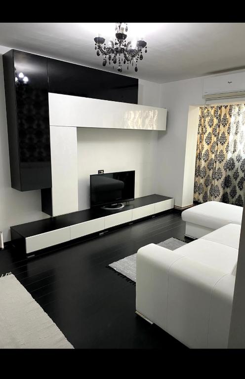 ein Wohnzimmer mit einem weißen Sofa und einem TV in der Unterkunft Apartament Nicolas in Brezoi