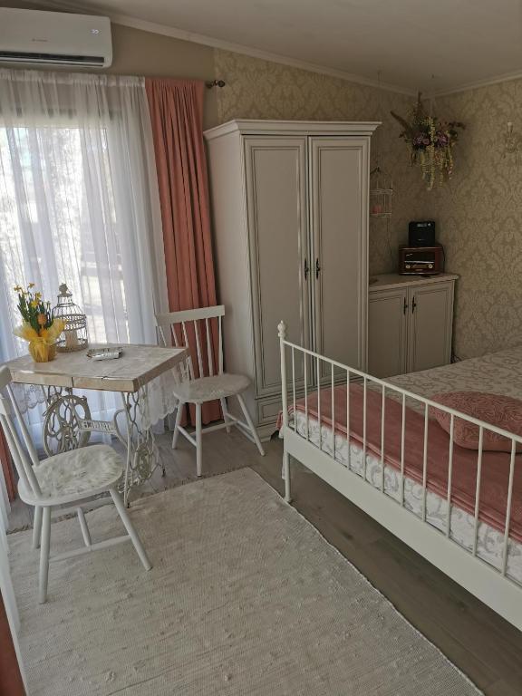 a bedroom with a bed and a table and a table and chairs at Holiday Home Kolka in Kolka