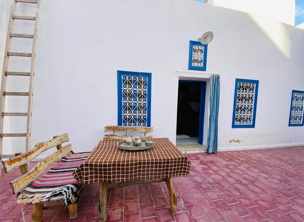 a room with a table and a chair and a ladder at Maison d'hôte Chama in Kairouan