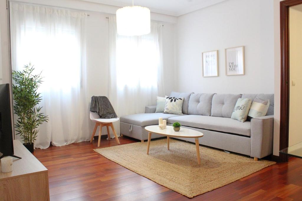uma sala de estar com um sofá e uma mesa em Apartamento centro paseo maritimo em Huelva