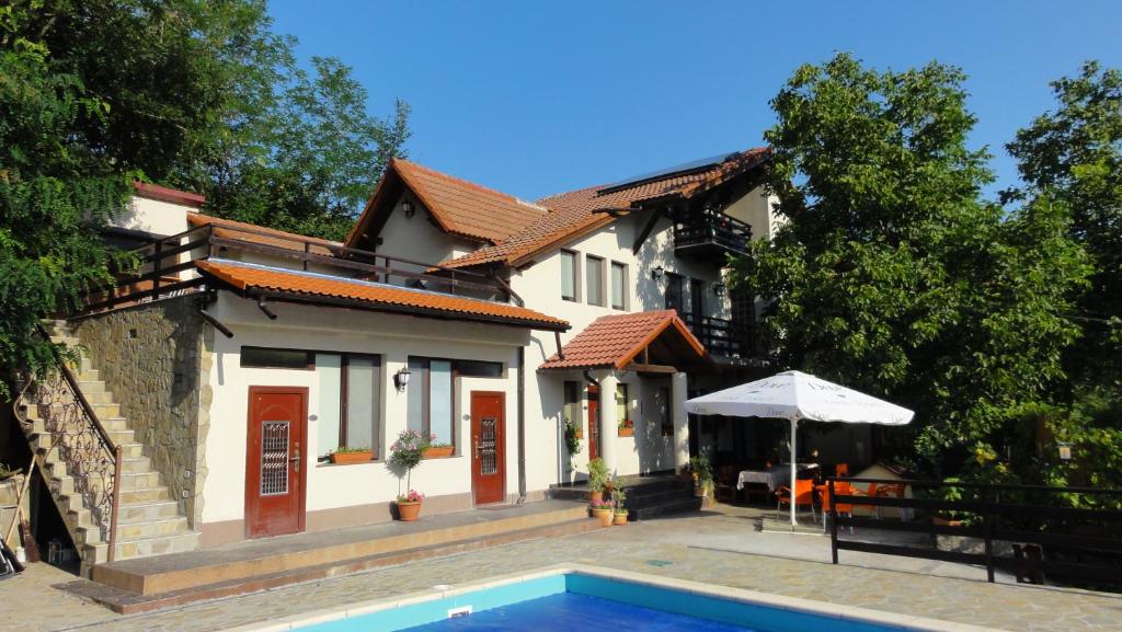 a house with a swimming pool in front of a house at Vila Europa in Sărata-Monteoru