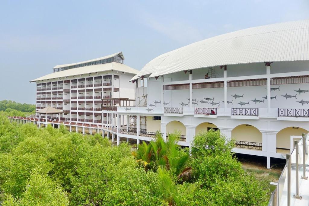ein weißes Gebäude mit nebenstehenden Tieren in der Unterkunft Pearl Laguna Resort in Mergui