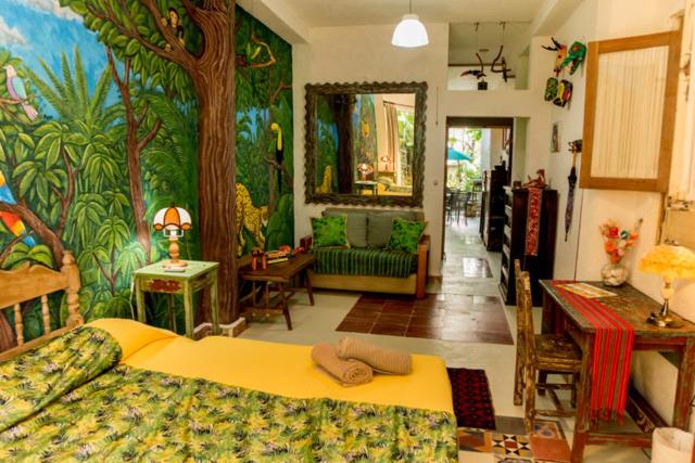 - une chambre avec un grand lit orné d'une peinture murale dans l'établissement Majikal B&B - La Selva, à Mérida