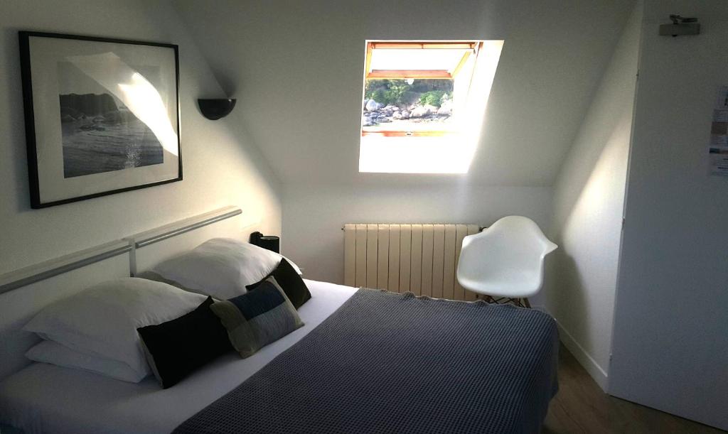 a bedroom with a bed and a window at Hotel De L'Europe in Perros-Guirec