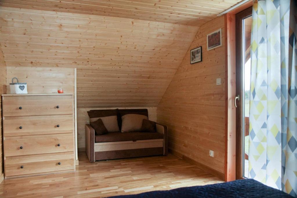 mały pokój z kanapą na poddaszu w obiekcie Domek Nad Stawem w mieście Kobylasz