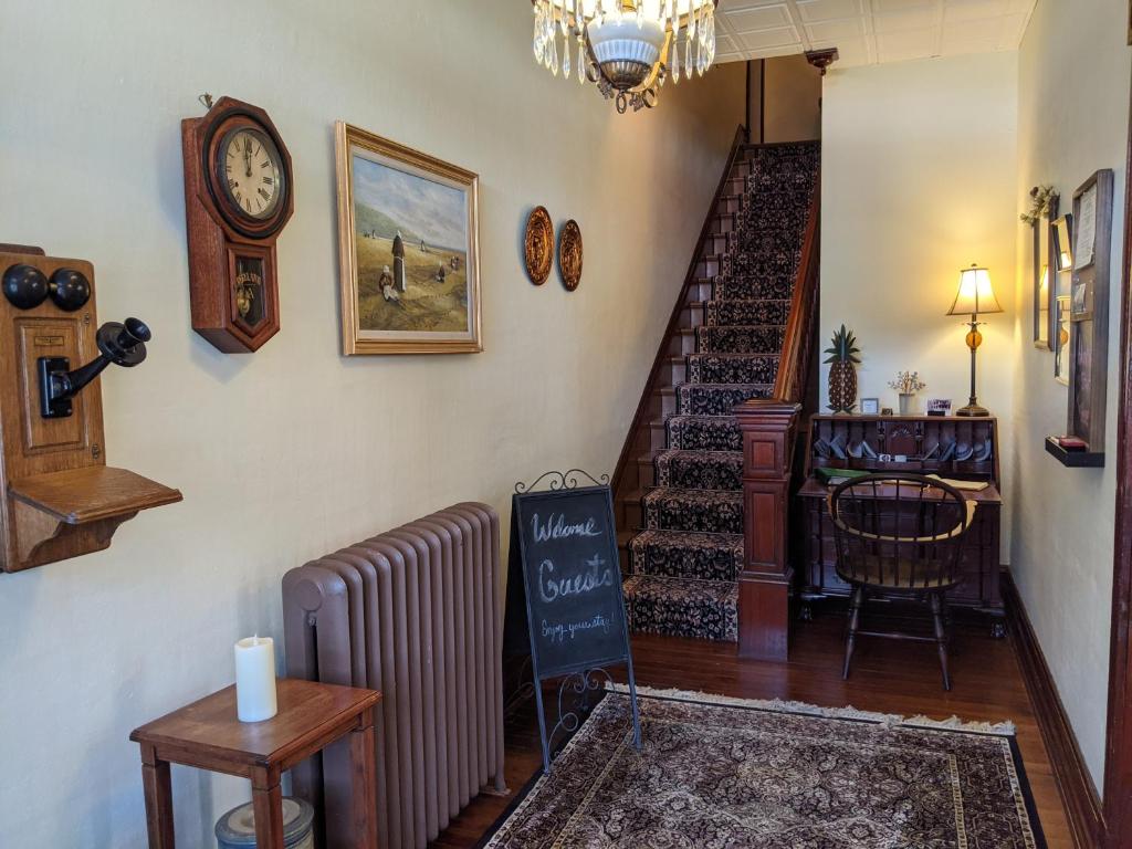 a hallway with a staircase and a clock on the wall at Lizard Creek Inn in Andreas